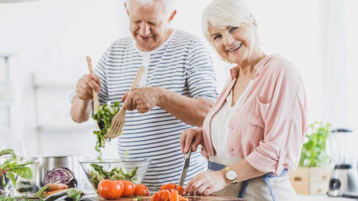 älteres Paar kocht gesundes Essen