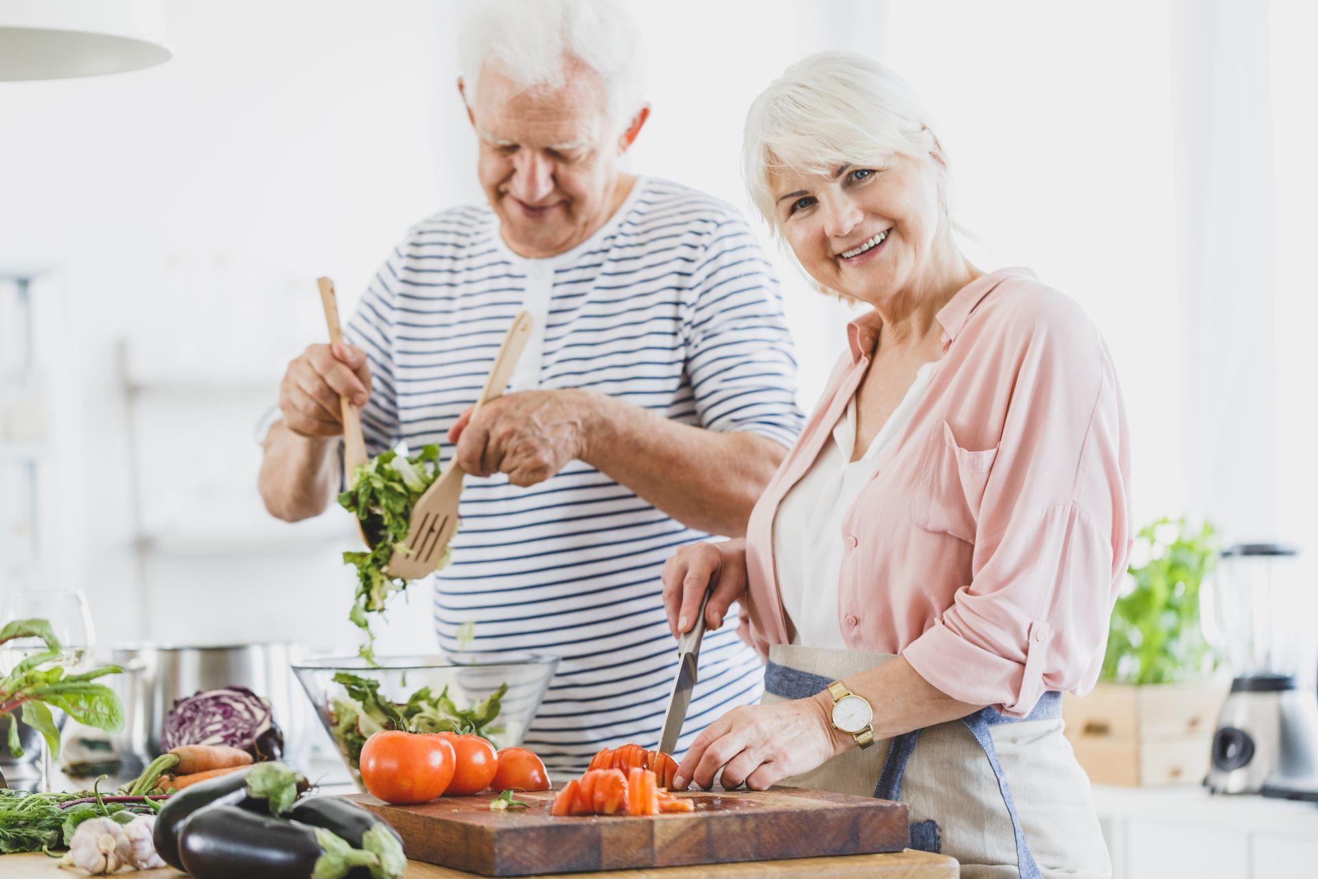 älteres Paar kocht gesundes Essen