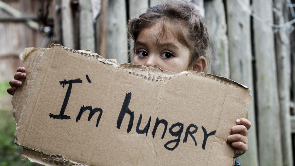 Mädchen mit Schild "Ich bin hungrig"