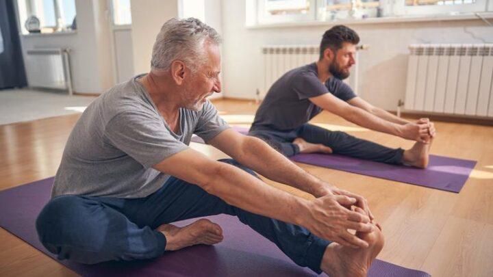 Yogi-Anfänger und sein Trainer üben Yoga