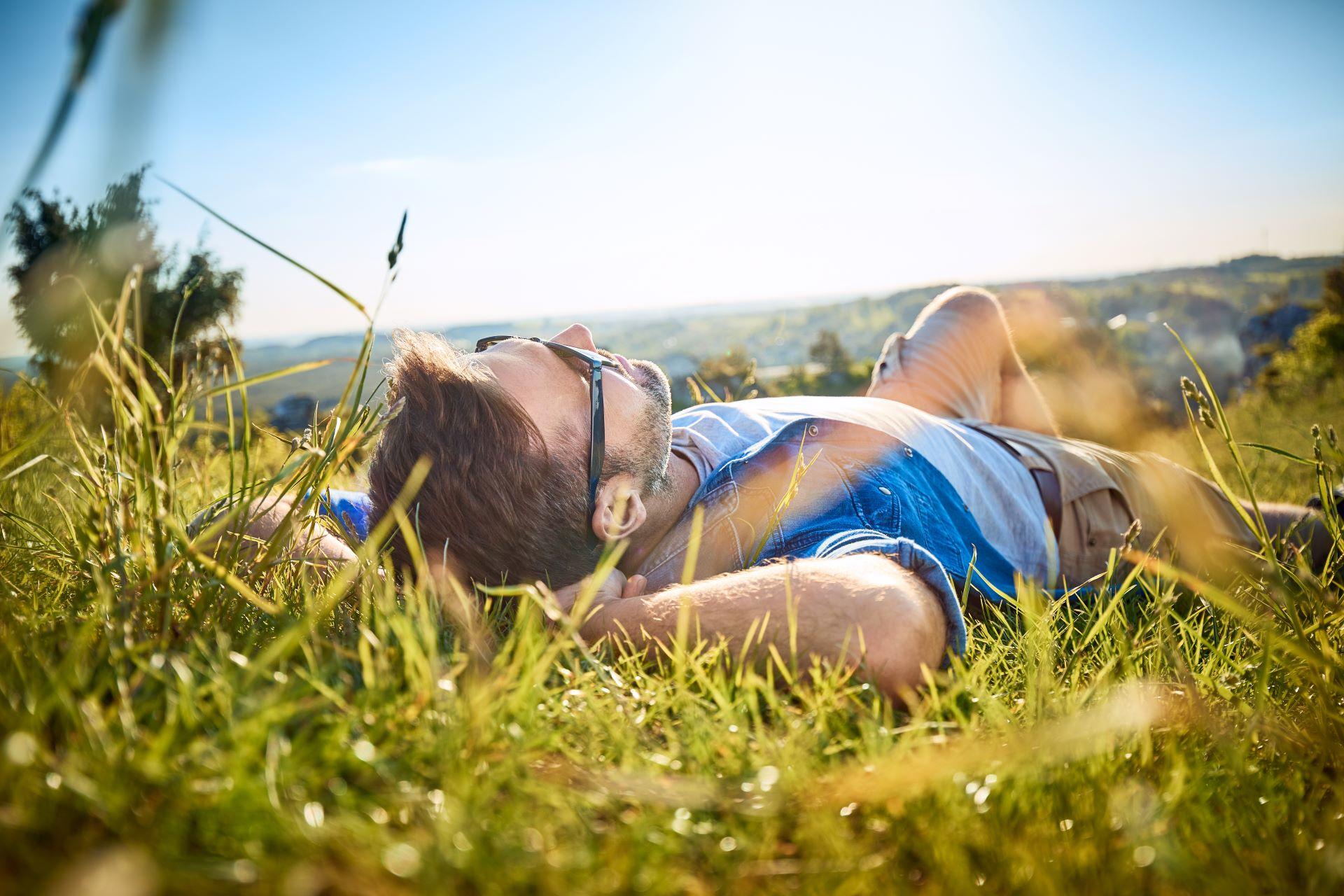 Mann entspannt sich im Gras in der Natur