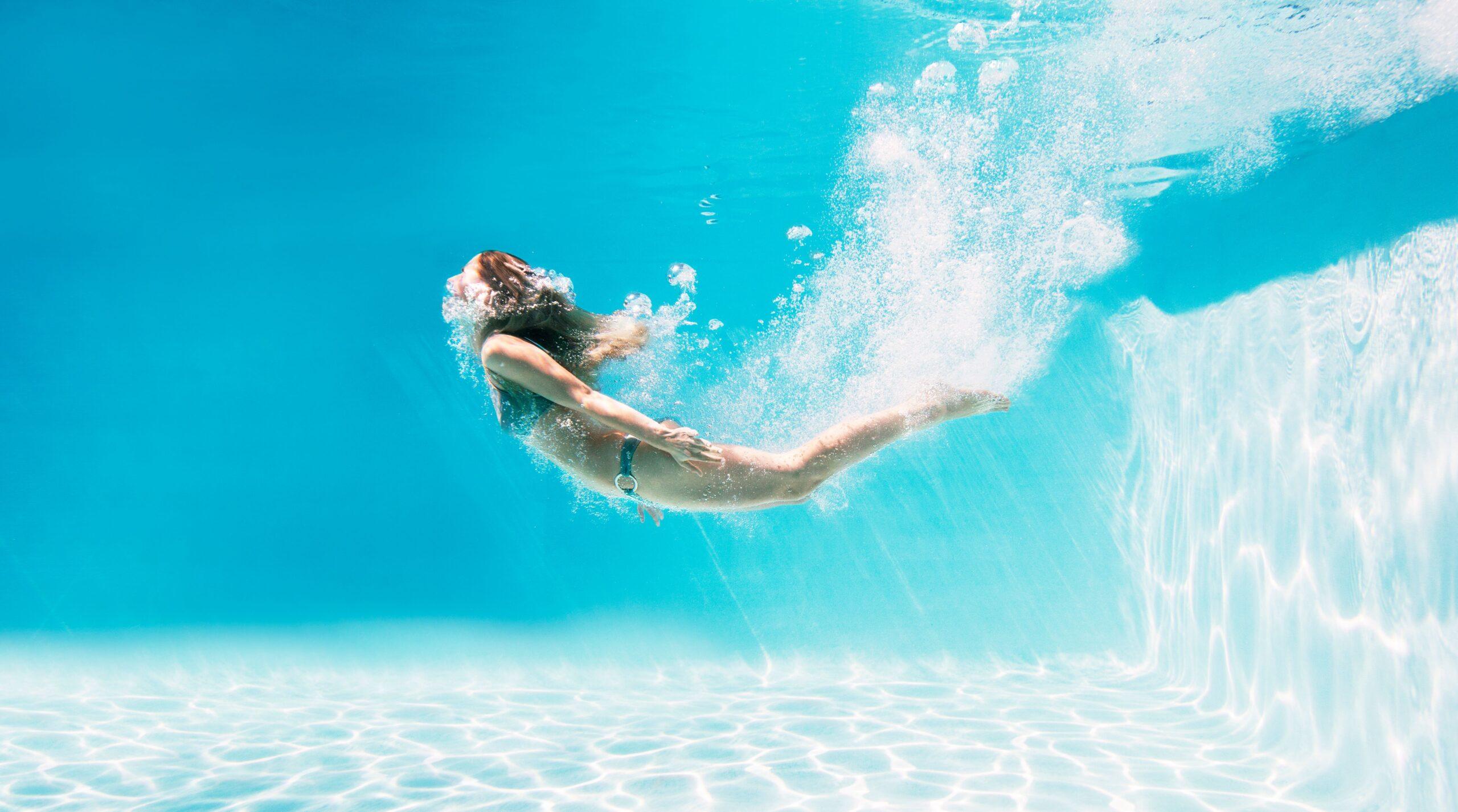 Eine Frau taucht im Pool