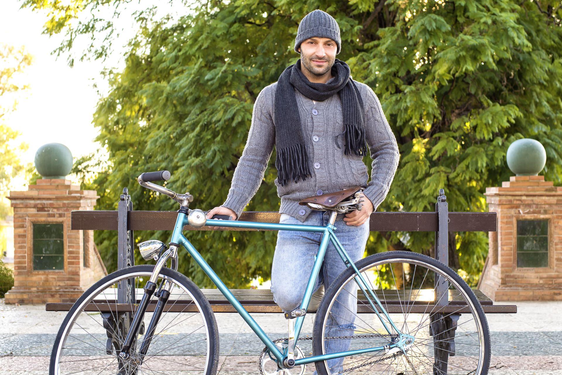 Mann mit Fahrrad und grauer Alpaka Mütze im Park