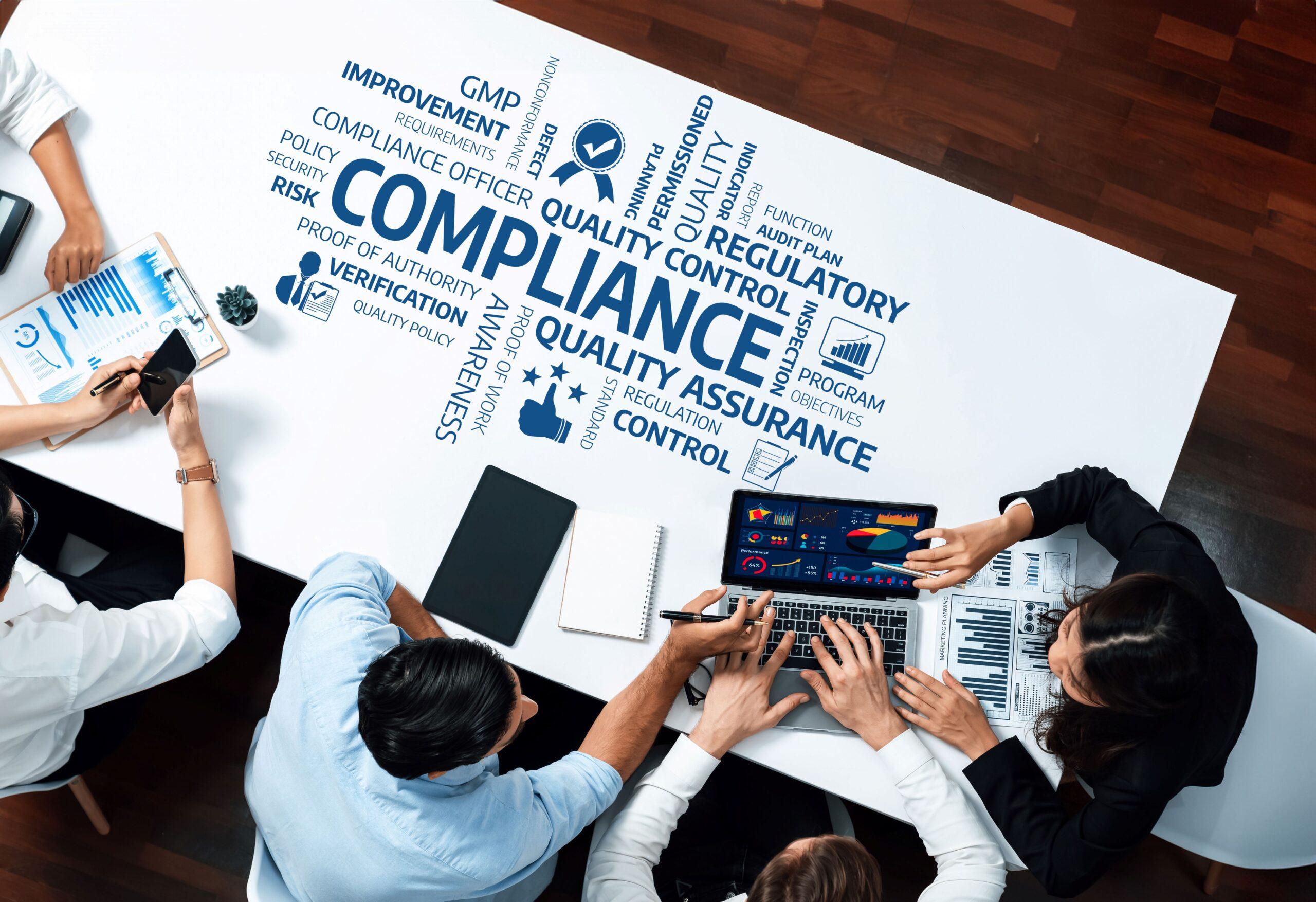 Compliance E-Learning: Team bespricht Qualitäts- und Kontrollprozesse am digitalen Konferenztisch mit Compliance-Schlagwörtern