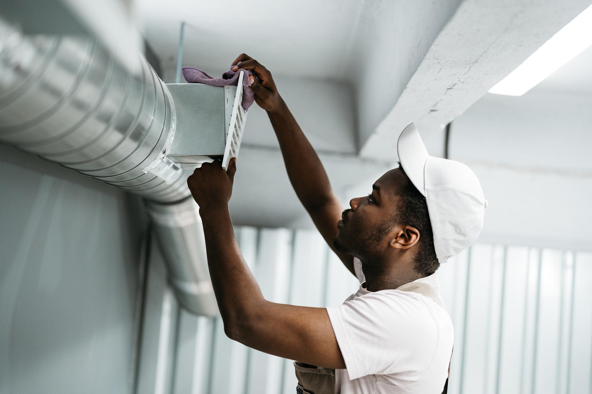 Techniker reinigt Lüftungskanal zur Verbesserung der Raumluft | Asbestsauger